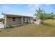 Covered back porch and picket fence provide a relaxing outdoor space in a grassy backyard at 5201 Dorman Rd, Lakeland, FL 33813