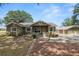 Inviting home exterior featuring a brick path, lush landscaping, and a detached garage, combining charm and functionality at 5201 Dorman Rd, Lakeland, FL 33813