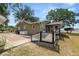 Exterior view of a cozy home featuring a backyard deck and a large grassy field with trees and landscape views at 5201 Dorman Rd, Lakeland, FL 33813
