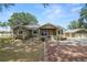 Charming single-story home with a covered front porch and beautiful trees on a sunny day at 5201 Dorman Rd, Lakeland, FL 33813