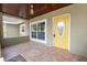 Covered porch featuring a yellow front door, tile flooring, and a wood ceiling, adding a touch of vintage charm at 5201 Dorman Rd, Lakeland, FL 33813