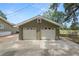 Two-car detached garage with two white doors, green walls, and well-maintained driveway at 5201 Dorman Rd, Lakeland, FL 33813