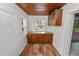 Hallway area with wood-look floors, wooden cabinets, and a window, providing a functional and stylish space at 5201 Dorman Rd, Lakeland, FL 33813
