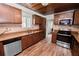 Well-lit kitchen with wooden cabinets, stainless steel appliances, and wood-look tile floor at 5201 Dorman Rd, Lakeland, FL 33813