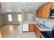Bright kitchen featuring tile floors, stainless steel appliances, and breakfast bar open to living room at 5201 Dorman Rd, Lakeland, FL 33813