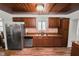 Kitchen with stainless steel refrigerator and dishwasher, wood cabinets, and tile backsplash at 5201 Dorman Rd, Lakeland, FL 33813