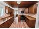 Charming kitchen featuring wooden cabinets, modern appliances, and wood-look tile flooring at 5201 Dorman Rd, Lakeland, FL 33813