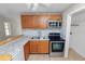 Kitchen features stainless steel appliances, wooden cabinets, tile backsplash, and double sink at 5201 Dorman Rd, Lakeland, FL 33813