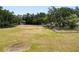 Expansive grassy area with mature trees providing shade and privacy, bordered by a fence at 5201 Dorman Rd, Lakeland, FL 33813