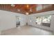 Inviting living room with bright natural light, white tile floor, wood-paneled ceiling, and a classic ceiling fan at 5201 Dorman Rd, Lakeland, FL 33813