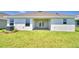 Backyard with green grass and a covered patio that includes glass paneled doors at 535 Tanaro Ln, Haines City, FL 33844