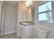 Bathroom featuring single granite sink with white vanity, toilet, and mirror with lighting at 535 Tanaro Ln, Haines City, FL 33844