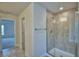 A shower with tile walls and a glass door, door opening up to another room at 535 Tanaro Ln, Haines City, FL 33844