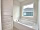 Large soaking tub near a window and adjacent to a five panel door at 535 Tanaro Ln, Haines City, FL 33844