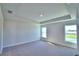 A bedroom with neutral walls, carpeted flooring, and two windows offers natural lighting and outdoor views at 535 Tanaro Ln, Haines City, FL 33844