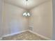 A dining area under a chandelier with neutral walls and tile flooring is illuminated by the hanging light fixture at 535 Tanaro Ln, Haines City, FL 33844