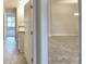 An entryway view to the living room with tile flooring and an adjacent bathroom featuring a granite-top vanity at 535 Tanaro Ln, Haines City, FL 33844