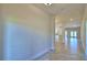Bright hallway featuring neutral tile flooring and smooth, light-colored walls leading to the kitchen at 535 Tanaro Ln, Haines City, FL 33844