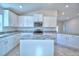 This kitchen offers white cabinets, granite countertops and stainless steel appliances including an island cooktop and microwave at 535 Tanaro Ln, Haines City, FL 33844