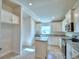 Bright kitchen with white cabinets, an island, granite counters, stainless steel appliances and tile floors at 535 Tanaro Ln, Haines City, FL 33844
