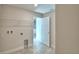The laundry room shows hookups, wire rack, and tile floors with a partial bathroom view through the open doorway at 535 Tanaro Ln, Haines City, FL 33844