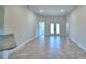 This living room features neutral walls, tile flooring, and access to the outdoor area through a set of glass doors at 535 Tanaro Ln, Haines City, FL 33844