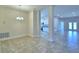 Open-concept living space features tiled floors, decorative columns, and views to the kitchen and back patio at 535 Tanaro Ln, Haines City, FL 33844