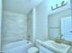 Modern bathroom with tiled walls, shower over tub, and granite countertop sink at 539 Tanaro Ln, Haines City, FL 33844