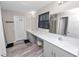 Bathroom features long vanity with dual sinks, light gray cabinets, wood-look floors and a shower at 5463 Arlington River Dr, Lakeland, FL 33811