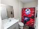 Bathroom with gray vanity, stylish mirror, and a shower showcasing a vibrant, themed shower curtain at 5463 Arlington River Dr, Lakeland, FL 33811