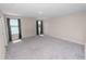 Spacious bedroom featuring gray carpet, two windows with dark curtains, and neutral-colored walls at 5463 Arlington River Dr, Lakeland, FL 33811