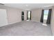 View of a bedroom, gray carpet, two windows with curtains, and an open doorway to a bathroom at 5463 Arlington River Dr, Lakeland, FL 33811