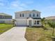 Charming two-story home with a two-car garage, well-manicured lawn, and lush landscaping at 5463 Arlington River Dr, Lakeland, FL 33811