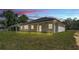 Back exterior of a single-story home with covered porch with ceiling fan and large windows overlooking the backyard at 5508 Odom, Lakeland, FL 33809