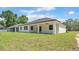 Back exterior of a single-story home with covered porch with ceiling fan and large windows overlooking the backyard at 5508 Odom, Lakeland, FL 33809