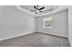 Bedroom with tray ceiling, fan, wood-look flooring, and a window overlooking trees at 5508 Odom, Lakeland, FL 33809