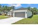 Exterior angled view of a single-story home with a gray roof, gray garage door, and landscaped front yard at 5508 Odom, Lakeland, FL 33809