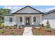 Close-up of front entrance with a gray decorative glass door, white columns, stone bases, and landscaped walkway at 5508 Odom, Lakeland, FL 33809