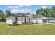 Charming single-story home with a gray roof, gray garage door, landscaped front yard, and inviting entrance at 5508 Odom, Lakeland, FL 33809
