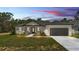 Charming single-story home with a gray roof, gray garage door, landscaped front yard, and inviting entrance at 5508 Odom, Lakeland, FL 33809