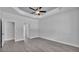 Main bedroom featuring tray ceiling, fan, wood-look flooring, and en suite access at 5508 Odom, Lakeland, FL 33809