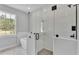 Bathroom with luxurious glass shower, garden tub, and tiled walls at 5508 Odom, Lakeland, FL 33809