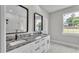 Bright bathroom featuring double vanity with granite countertop and sleek, modern fixtures and marble floors at 5512 Odom Rd, Lakeland, FL 33809