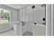 Modern bathroom showcasing a luxurious glass enclosed shower and a freestanding soaking tub with backyard views at 5512 Odom Rd, Lakeland, FL 33809