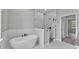 Modern bathroom featuring glass shower, sleek soaking tub, and elegant marble floors at 5512 Odom Rd, Lakeland, FL 33809