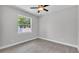 Bright bedroom with wood-look tile flooring, a ceiling fan, and a window offering natural light at 5512 Odom Rd, Lakeland, FL 33809