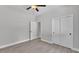 Neutral bedroom showcases wood-look tile flooring, a ceiling fan, closet doors, and a doorway to an adjacent room at 5512 Odom Rd, Lakeland, FL 33809