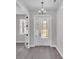 Elegant entryway featuring a decorative glass door, chandelier, and wood-look tile flooring at 5512 Odom Rd, Lakeland, FL 33809