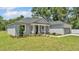 Charming single-story home features a manicured lawn and a welcoming front entrance with decorative columns at 5512 Odom Rd, Lakeland, FL 33809