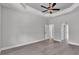 Spacious main bedroom boasts trey ceiling with fan, wood-look tile flooring, and ensuite bath and walk-in closet at 5512 Odom Rd, Lakeland, FL 33809